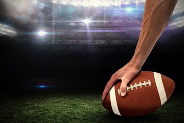 Composite image of american football player placing the ball