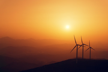wind turbines silhouette on mountain at sunset
