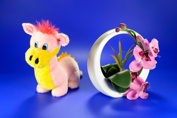 Pink dragon with a decorative vase of flowers