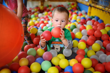 Fototapeta na wymiar baby boy looking with surprise at the colored balls. child squin