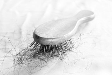 comb brush with lost hair on white cloth