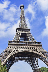 The iconic Eiffel Tower in Paris against a cloudy blue sky, France.