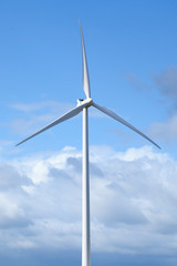 White modern windmill against a cloud sky.