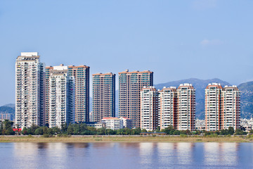 Luxury apartment buildings with river view near mountain ridge, Wenzhou, China