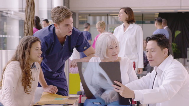  Caring medical staff in modern hospital discuss x-ray results with a patient