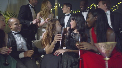 Happy group of friends at glamorous party, drinking champagne and celebrating