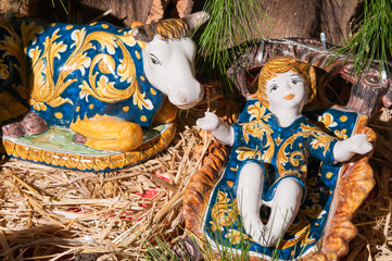 Painted pottery statue portraying baby Jesus in the ceramic nativity scene of an artisan in Caltagirone
