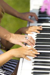 Obraz premium Игра на рояле в четыре руки - играют мама и дочка