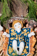 Painted pottery statue portraying baby Jesus in the ceramic nativity scene of an artisan in Caltagirone