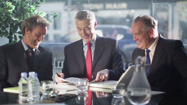  Friendly cheerful businessmen shake hands at end of a business meeting