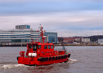 A red navy ship with modern cities on a background in Aarhus, Denmark. Vertical view