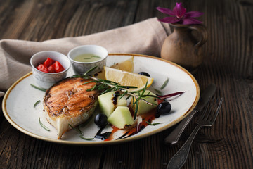 Grilled salmon on a plate with sauce and spices