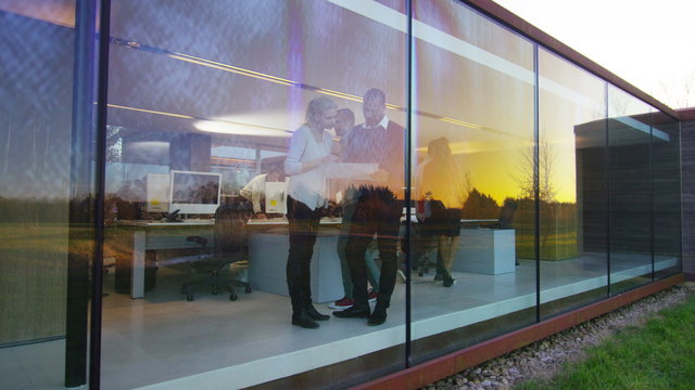  Designers or architects in meeting seen through the glass of modern office