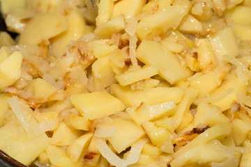 potatoes and onions in a frying pan as background