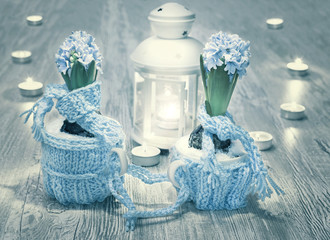 Blue hyacinths with wool decorations and candles on wood