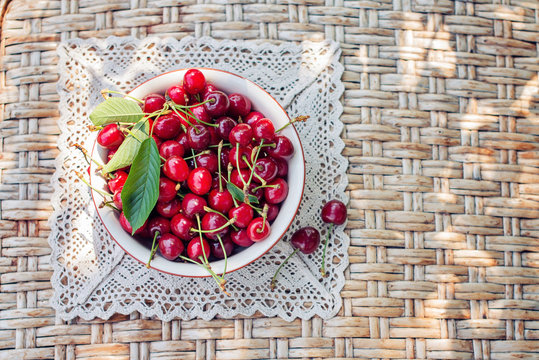 Sweet cherries on the plate on the table, top view