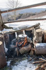 Cooking in field conditions, boiling pot at the campfire on picn