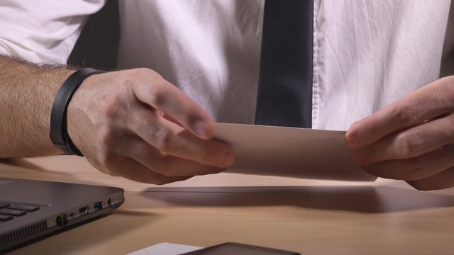Businessman reading letter of rejection, crumbling paper and envelope and throwing it away, work desk close up.