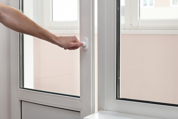 Naklejka premium The human hand close a plastic vinyl door.