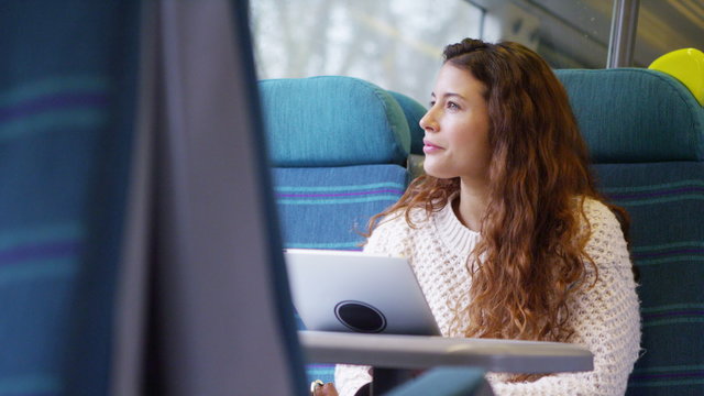  attractive female using her digital tablet on a moving train