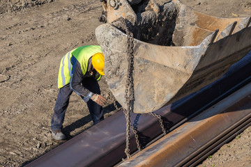 Construction worker attaching lifting chains