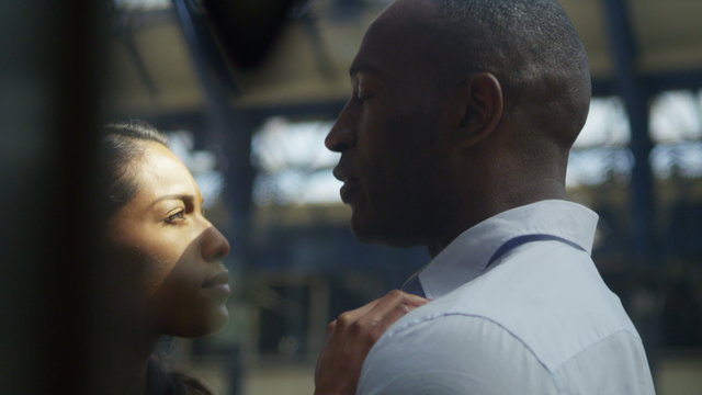  Attractive ethnic couple in love saying goodbye on train station platform.