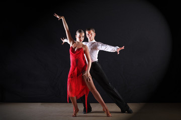 dancers in ballroom against black background