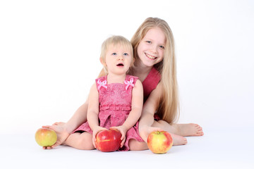 Fototapeta premium adorable little two sisters 9 year and 1 year old with apple o