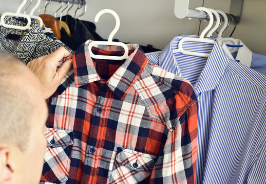 Young Man Picking A Shirt From The Closet