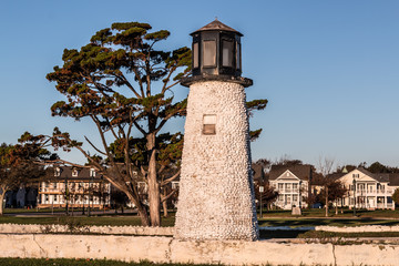 Buckroe Beach lighthouse in Hampton, Virginia with houses in background.