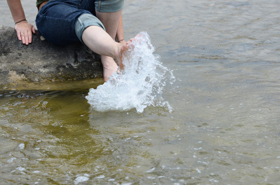Woman splashing feet in sea