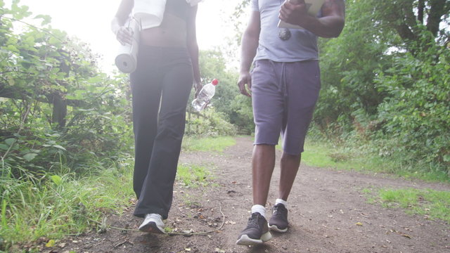 Young sports woman with personal trainer walking and talking. Slow motion