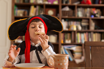 Young boy dressed up as pirate eating sandwich