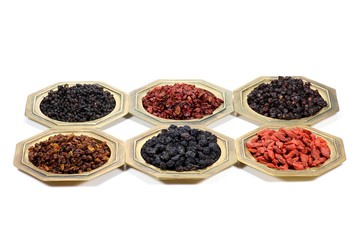 Auswahl getrockneter Beeren (Aronia, Sanddorn, Goji, Berberitzen, Schisandra, Hollunder) isoliert auf weißem Hintergrund