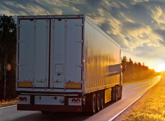 White truck on the rural road in evening