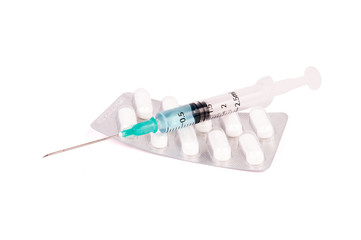 Packs of white pills with syringe