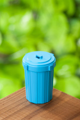 青色のゴミ箱 緑色の背景