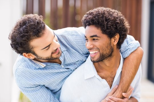 Smiling gay couple embracing each other