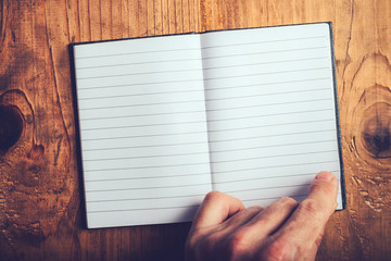 Man flipping pages of blank notebook