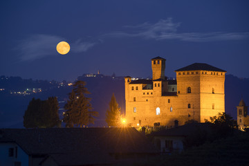 Castle of Grinzane Cavour in nocturnal with a full moon
