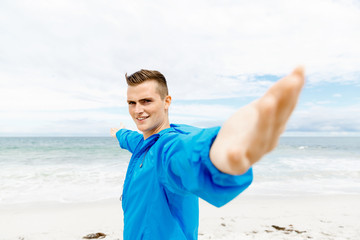 Young man in sport wear with outstretched arms