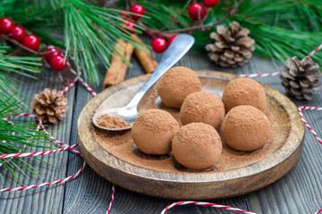 Homemade chocolate-caramel truffles on a wooden plate