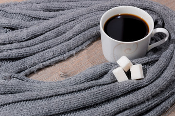 Кружка горячего черного кофе и шерстяной шарф