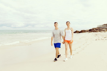 Runners. Young couple running on beach