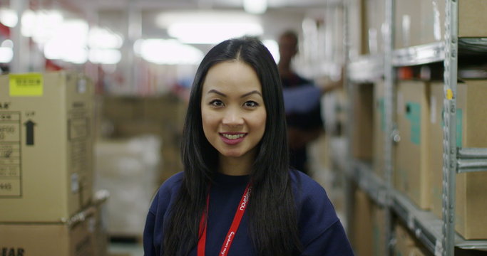 Portrait of cheerful female worker in a warehouse or factory