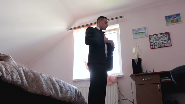 The groom wears a jacket before the wedding.