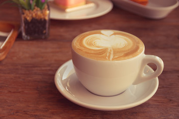 Close up cup of Coffee, latte on the wooden table - Vintage Filter Effect