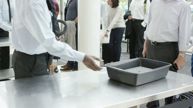  Airport security guards on duty, searching passengers before a flight