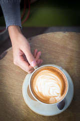 woman is holding cup of coffee