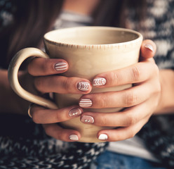 Girl's hands holding a cup of coffee